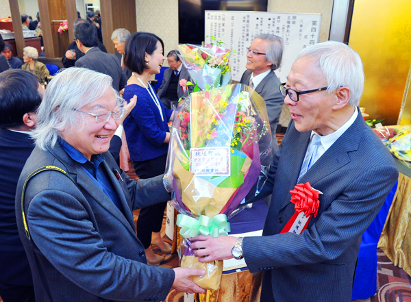 花束を贈呈される秋道名誉教授（右）