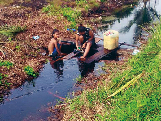 赤い水で洗濯する住民