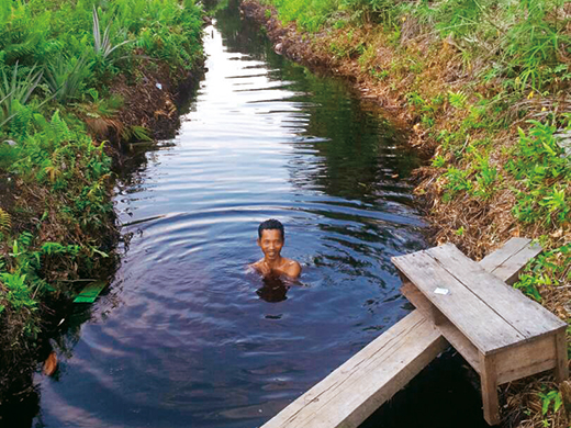 赤い水で水浴びする住民