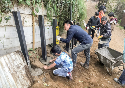 Micro-practice with local people to mitigate erosion by building pilling walls in Barrio Cantera, an informal settlement with landslide risk in San Martin de los Andes, Argentina. October 2018.